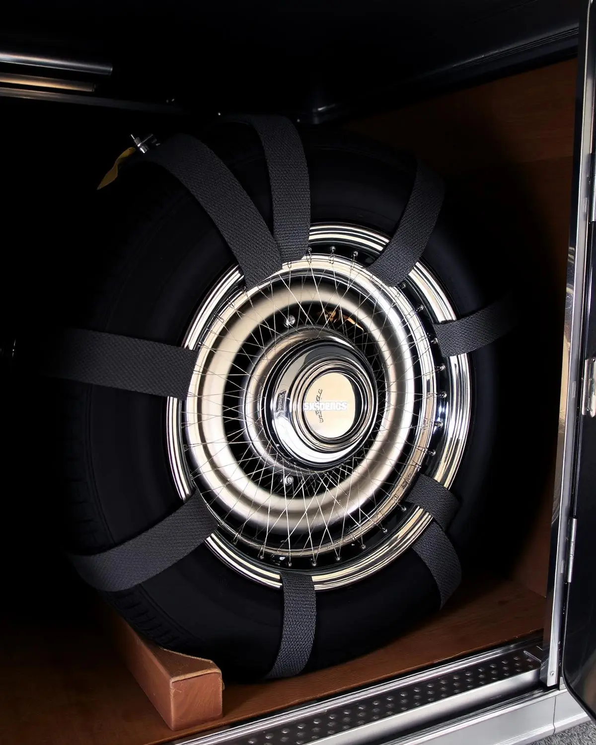 Collector vehicle secured inside an enclosed transporter with padded soft-tie wheel straps